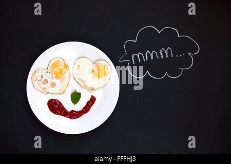 La prima colazione, uova fritte in forma di cuori, Smile, buon umore, mattino luminoso, sfondo Foto Stock
