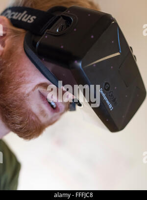 Un uomo (etnia Caucasica) indossa Oculus Rift Development Kit 2 (DK2) la realtà virtuale gli occhiali di protezione durante la riproduzione di un gioco per computer Foto Stock