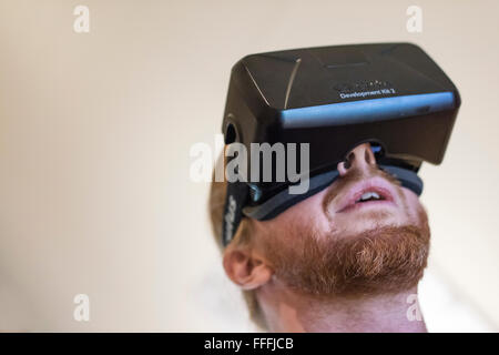 Un uomo (etnia Caucasica) indossa Oculus Rift Development Kit 2 (DK2) la realtà virtuale gli occhiali di protezione durante la riproduzione di un gioco per computer Foto Stock