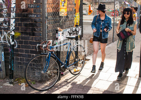 Due eleganti hipster ragazze camminando in Brick Lane, Shoreditch. Foto Stock