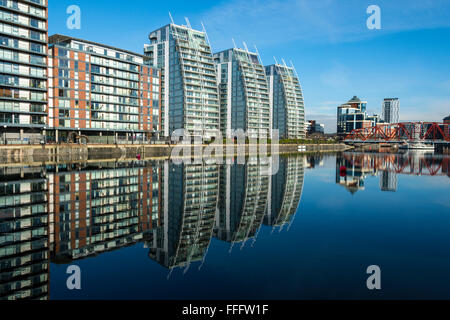 City Loft e NV blocchi di appartamenti e il Victoria Building, riflessa in Huron bacino, Salford Quays, Manchester, Inghilterra, Regno Unito Foto Stock