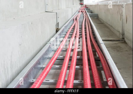 Il cavo di alimentazione che stabilisce in scaletta per cavi in sito in costruzione Foto Stock