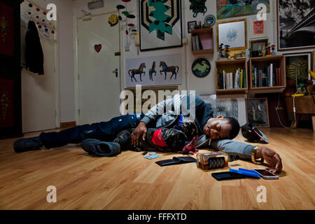 Giovane uomo dorme sul pavimento con un cane lasciando un mass. Foto Stock