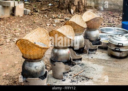 La cottura a vapore del riso glutinoso(riso appiccicoso) in una cucina tailandese. Foto Stock