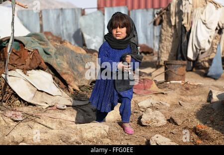A Kabul, Afghanistan. Xiii Febbraio, 2016. Un sfollati afghani bambino sorge fuori la sua tenda a Kabul, capitale dell'Afghanistan, Feb 13, 2016. Credito: Rahmat Alizadah/Xinhua/Alamy Live News Foto Stock