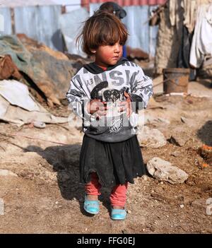 A Kabul, Afghanistan. Xiii Febbraio, 2016. Un sfollati afghani bambino sorge fuori la sua tenda a Kabul, capitale dell'Afghanistan, Feb 13, 2016. Credito: Rahmat Alizadah/Xinhua/Alamy Live News Foto Stock