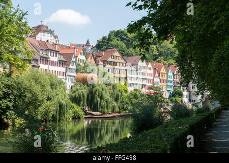 Alcune case colorate accanto al fiume tra gli alberi su una soleggiata giornata estiva. Tübingen, sul fiume Neckar, Germania Foto Stock