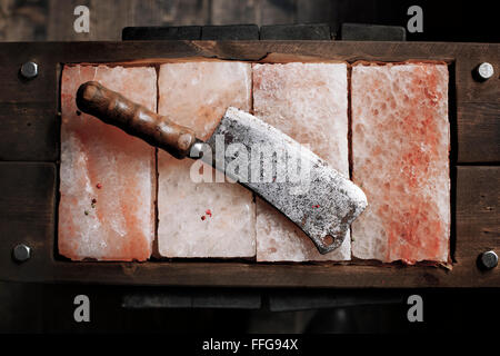 Carne Vintage cleaver su Himalayan sale rosa. Piastre di sale. Barre di sale per la cottura. Coltello da cucina ax- immagine Stock Foto Stock