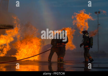 Tre studenti assegnati al 312Training Squadron battaglia un incendio durante un crash recovery lo scenario di addestramento al Louis F. Garland Dipartimento della Difesa Fire Academy, dal 15 ottobre 2015. Durante il recupero in caso di crash di formazione, gli studenti imparano a gestire un incendio e conservare alcuni dei militari più altamente ambita aerei in caso di emergenza incendio situazioni. Il DOD comune scuola è compreso di Air Force, Esercito, Marina, Marine e di servizio civile gli studenti. Foto Stock