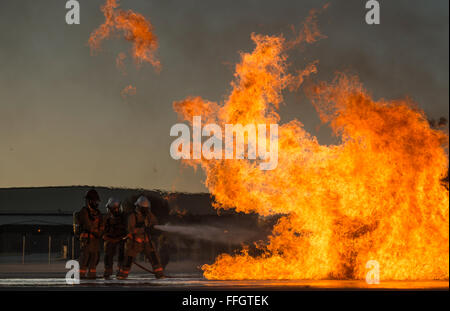 Tre studenti militare assegnato al 312Training Squadron battaglia un incendio durante un liquido scenario di incendio al Louis F. Garland Dipartimento della Difesa Fire Academy, dal 15 ottobre 2015. Durante il fuoco liquido di formazione, gli studenti ruotare attraverso 3-uomo iterazioni di bassa e alta incendi mentre si muove attraverso l'acqua. Il DOD comune scuola è compreso di Air Force, Esercito, Marina, Marine e di servizio civile gli studenti. Foto Stock