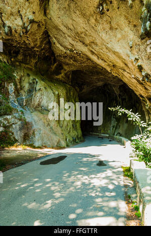 La Cuevona, tunnel naturale che attraversa la strada a Cuevas del Agua. Rivadesella, Asturias, Spagna Foto Stock