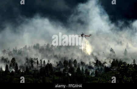 Un elicottero scende acqua sul fuoco come i vigili del fuoco continuano a combattere il blaze che ardeva nelle ore serali in Waldo Canyon per gli Stati Uniti Air Force Academy. Funzionari ha stimato che il fuoco si era diffuso in circa dieci ettari di terreno appartenente all'Accademia. Foto Stock