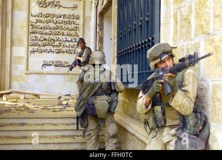 US Marine Corps (USMC) Marines dal 1° Battaglione, 7 Marines (1/7), Charlie Company, ventinove palme, California (CA), coprire ogni altro con 5,56 mm M16A2 fucili di assalto che si preparano a entrare in uno dei palazzi di Saddam Hussein a Baghdad come loro presa in consegna il complesso durante l'Operazione Iraqi Foto Stock