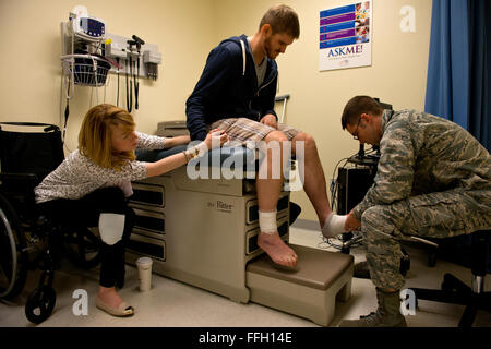 Il tenente Justin agricoltore, un assistente medico presso la 66Clinica Medica, Hanscom Air Force Base, Massachusetts, conduce un follow up esame con il cap. Adam Davis, affiancato dalla moglie Adrianne, per controllare i progressi della sua guarigione. Foto Stock