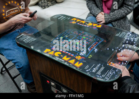 Le persone che giocano un vintage Pac-Man video game arcade - USA Foto Stock