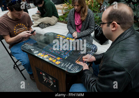 Le persone che giocano un vintage Pac-Man video game arcade - USA Foto Stock