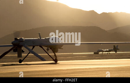 Un MQ-1B Predator (sinistra) e un MQ-9 Reaper taxi per la pista in preparazione per il decollo a Creech Air Force Base, Nev. Gli aerei sono assegnati al parafango 432nd, quali treni, piloti, sensore degli operatori e delle altre pilotato a distanza equipaggi degli aeromobili, e conduce la lotta contro la sorveglianza e le operazioni di attacco in tutto il mondo. Foto Stock