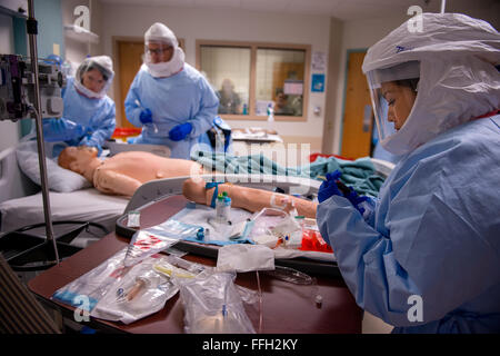 Stati Uniti Air Force Capt. Tanya Tsosie aspira il sangue da una simulazione di Ebola e paziente durante una settimana di corso di formazione presso il San Antonio militare Centro Medico, Texas. Tsosie è un infermiere assegnato ad un 30-stati medical response team progettato per il supporto di civili professionisti medici in caso di epidemia di Ebola negli Stati Uniti. Foto Stock