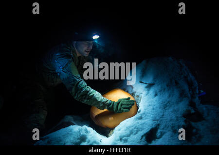 Il personale Sgt. Seth Reab, det. 1, 66Training Squadron, Arctic sopravvivenza istruttore della Scuola, fissa un termalizzati telaio a ricovero per uno studente durante arctic survival training. Gli studenti sono incoraggiati ad entrare nella loro termalizzati telaio a rifugi per ottenere il resto per il giorno successivo alle 2000 ore ogni notte. Foto Stock