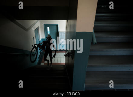 Senior Airman David Flaten porta la sua bici su per le scale fino al suo appartamento in Harrisonburg, Virginia. Flaten spostato a Harrisonburg, una zona conosciuta per i suoi impegnativi, rocciosa, terreno montuoso e i ciclisti professionisti che treno vi, pochi mesi dopo che è stato selezionato per la Air Force atleta di classe mondiale Programma. Foto Stock