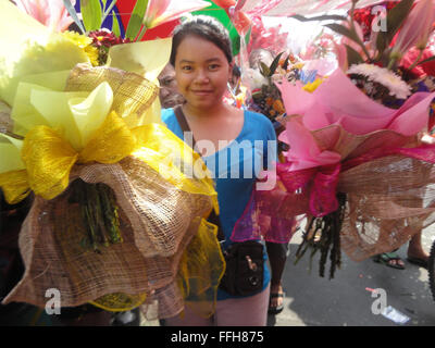 Manila, Filippine. Xiv Feb, 2016. Filippini portano mazzi di rose lungo il Dangwa mercato dei fiori a Manila nelle Filippine il giorno di San Valentino. Il giorno di San Valentino è celebrata il 14 febbraio di ogni anno. Credito: Richard James M. Mendoza/Pacific Press/Alamy Live News Foto Stock