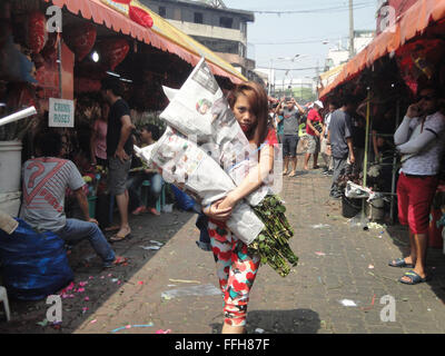 Manila, Filippine. Xiv Feb, 2016. Filippini portano mazzi di rose lungo il Dangwa mercato dei fiori a Manila nelle Filippine il giorno di San Valentino. Il giorno di San Valentino è celebrata il 14 febbraio di ogni anno. Credito: Richard James M. Mendoza/Pacific Press/Alamy Live News Foto Stock