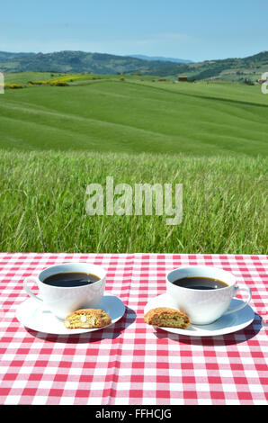 Due tazze di caffè sul tavolo di legno contro il paesaggio toscano, Italia Foto Stock