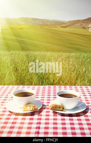 Due tazze di caffè sul tavolo di legno contro il paesaggio toscano, Italia Foto Stock