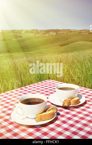 Due tazze di caffè sul tavolo di legno contro il paesaggio toscano, Italia Foto Stock