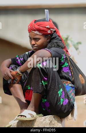 SENBETE, ETIOPIA-marzo 24, 2013: Donna si siede su una roccia e attende al di fuori del mercato di domenica dove il oromos-amharas-Afar si incontrano. Foto Stock
