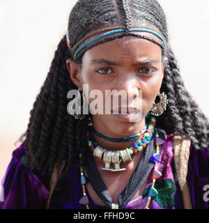 SENBETE, ETIOPIA-marzo 24: Donna con braidshairstyle attende la sua famiglia al di fuori del mercato di domenica. Oromos-amharas-afar soddisfare Foto Stock