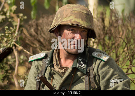 Uomo vestito come Seconda Guerra Mondiale soldato tedesco pronto a prendere parte alla battaglia rievocazione. Foto Stock