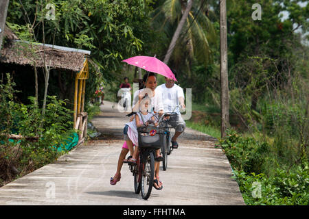 Turisti asiatici giro dell'isola in bicicletta. Ko Kret (anche Koh Kred) è un'isola del fiume Chao Phraya, 20 km a nord di Bangko Foto Stock