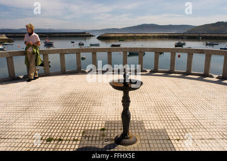 Modo di San Giacomo, Ruta Jacobea. Un turista in promenado di un villaggio Cruz, Muxía. St. James's Way, St. James's percorso, St. James's Trail, itinerario di Santiago de Compostela o Cammino di Santiago Foto Stock