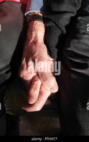 Coppia di anziani maschi e femmine tenendo le mani ancora in amore close up Foto Stock