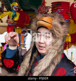 Londra, Regno Unito. 14 feb 2016. Un venditore in veste tradizionale e un Lion hat vende decorazioni Cinesi su Trafalgar Square come parte del Capodanno cinese. Festeggiamenti celebrare l Anno della Scimmia, che è iniziata il 8 febbraio. London's celebrazioni sono detto di essere il più grande al di fuori della Cina. Foto Stock
