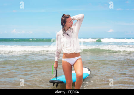 Girl sulle onde del mare con la sua tavola da surf. Immagine di stock Foto Stock