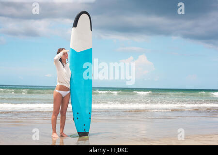 Girl sulle onde del mare con la sua tavola da surf. Immagine di stock Foto Stock