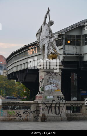 Graffiti copre una ringhiera, panca e statua di base al successivo a S-Bahn fermata del treno a Berlino, Germania. Foto Stock