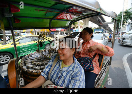 Tailandese donne il trasporto di pesce in un Tuktuk. Foto Stock