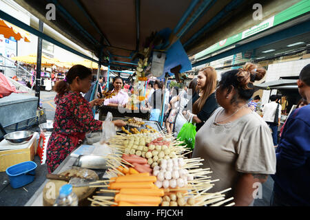 Cibo di strada a Bangkok. Un mobile bancarella vendendo gli spiedini di grigliate di carne, polpi e salsicce. Foto Stock