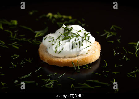Close up di un cracker di grano con crema di formaggio e guarnire aneto Foto Stock