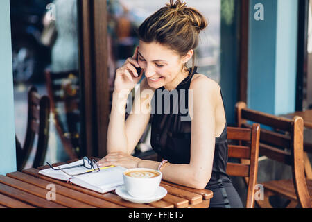 Affascinante ragazza parlando al telefono Foto Stock