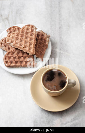 A forma di cuore e di cialde di caffè sul tavolo, dal di sopra Foto Stock