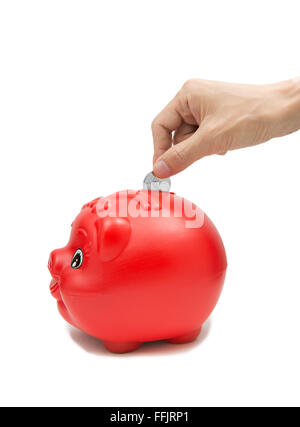 Mano inserire una moneta nell piggybank isolati su sfondo bianco Foto Stock