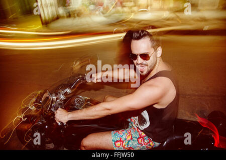 Giovane uomo su un motociclo di notte Foto Stock