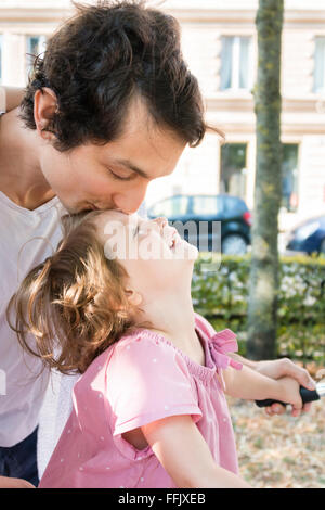 Padre baciare la figlia di fronte Foto Stock