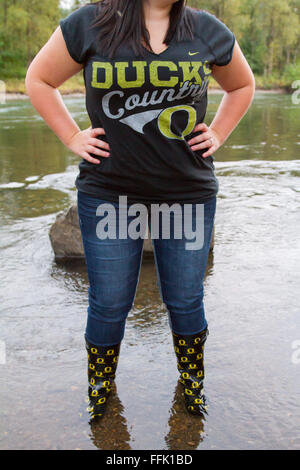 SPRINGFIELD, o 14 SETTEMBRE 2011: donna in piedi in acqua indossando Oregon Ducks football team stivali da pioggia. Foto Stock