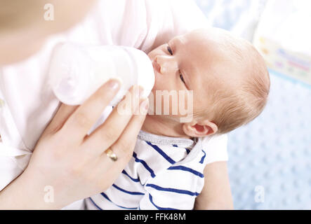 Bottiglia-fed baby. Una donna che alimenta un neonato con latte modificati da una bottiglia. La madre è la alimentazione neonato Foto Stock