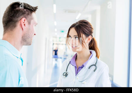 Maschio e femmina medico parlando in ospedale corridoio Foto Stock